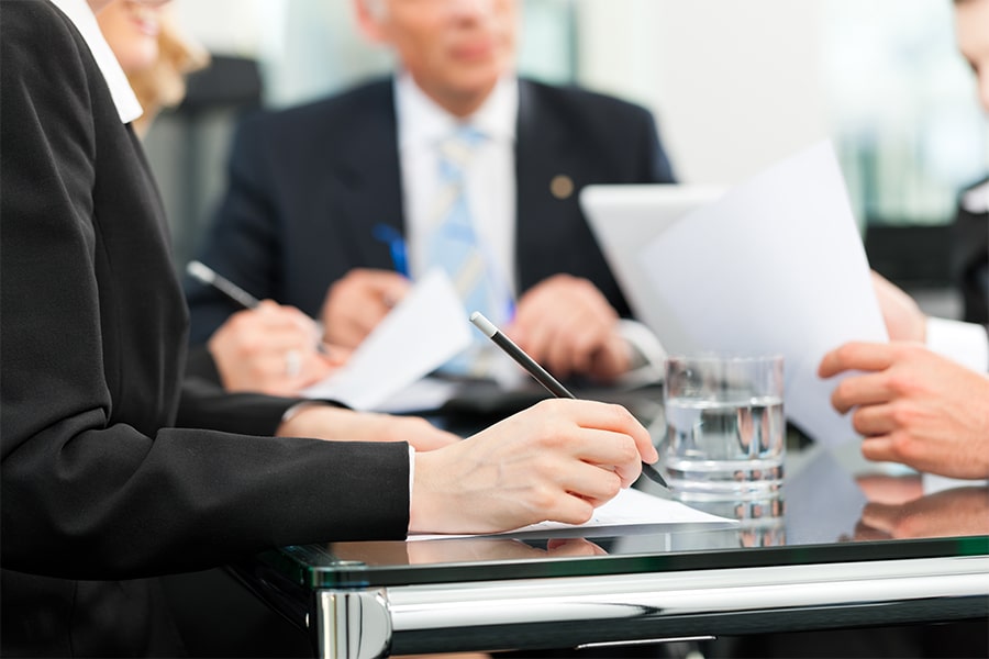 three businessmen signing papers